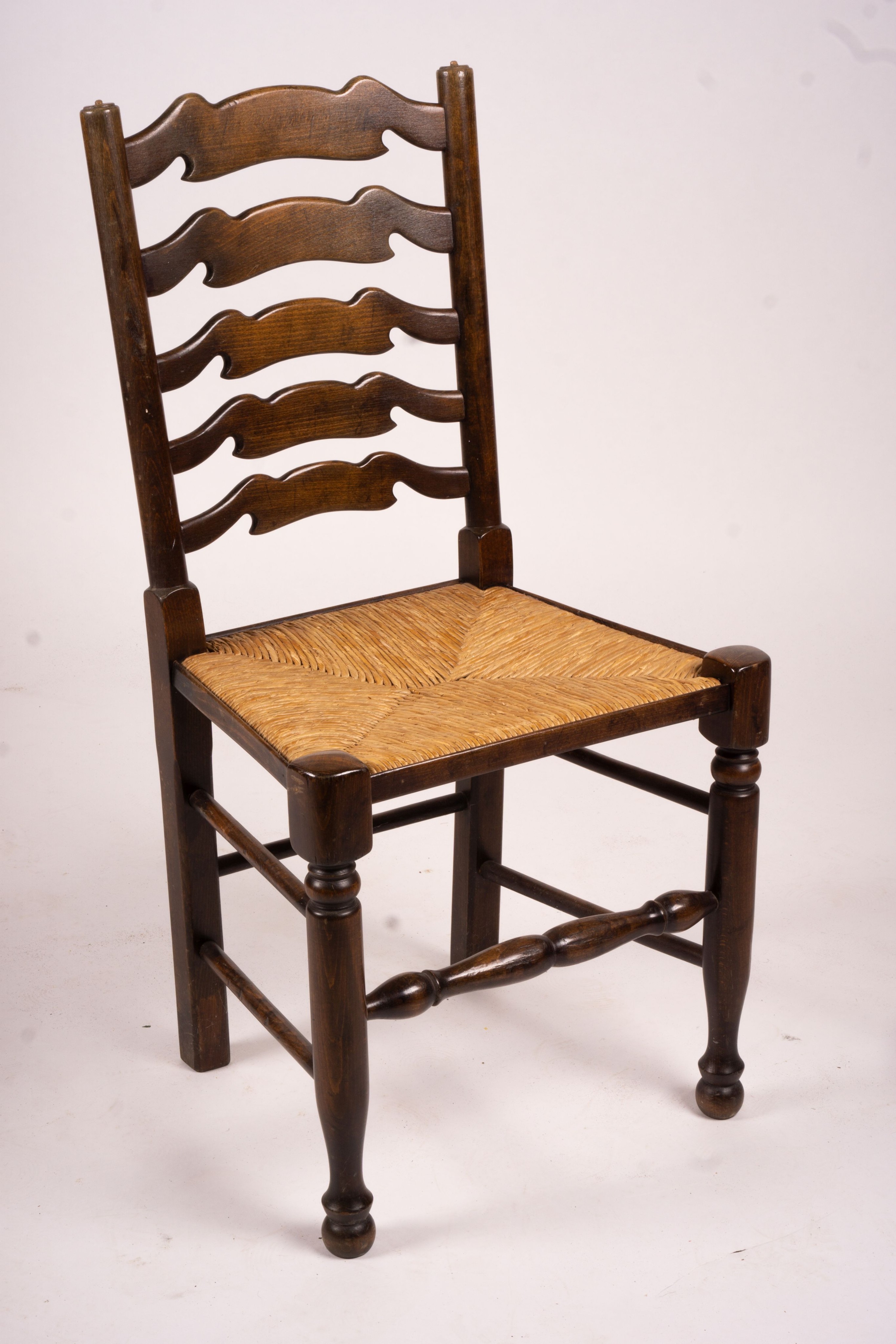 A set of ten 18th century style beech ladderback rush seat dining chairs, two with arms